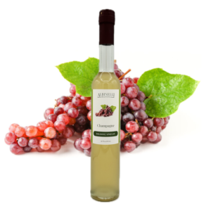 Champagne grapes behind a bottle of balsamic vinegar