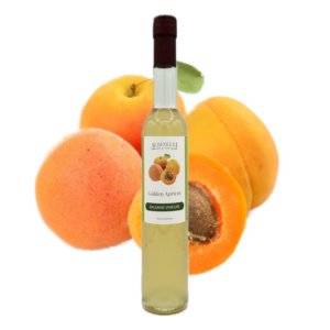 a bottle of balsamic in front of a grouping of apricots